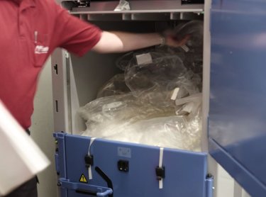 Brazo mecánico introduce plástico en la prensa de balas