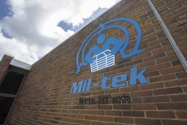 logotipo de Mil-tek en una pared de ladrillo exterior