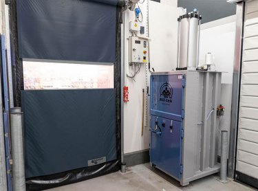 Prensa de balas junto a la puerta trasera