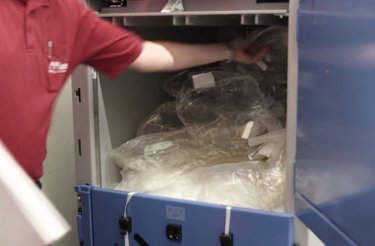 Hombre poniendo plástico en una prensa de balas A305