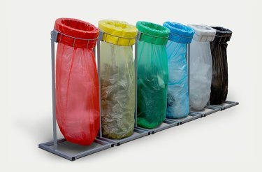 Bolsas de residuos de colores en un soporte
